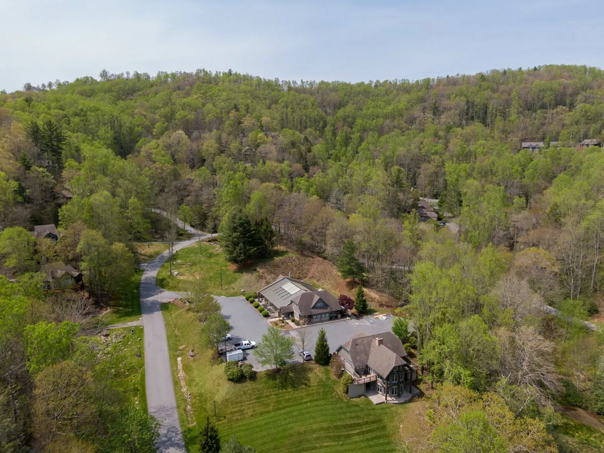 This image captures the main building surrounded by lush trees and peaceful roadways, evoking a sense of immersion in nature. The setting suggests easy access to hiking and nature walks, connecting visitors directly with the outdoors.